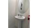 Powder room featuring a pedestal sink, oval mirror, neutral walls, and modern fixtures at 5521 Summit Gln, Bradenton, FL 34203