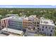 Aerial view of a modern condo building with colorful exterior, showing proximity to lush surroundings at 555 N Orange Ave # 307, Sarasota, FL 34236