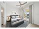 Cozy bedroom with a ceiling fan, decor, and a balcony with bright light at 555 N Orange Ave # 307, Sarasota, FL 34236