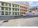 Multi-story condo building with pastel colors and parking lot view, close to downtown amenities at 555 N Orange Ave # 307, Sarasota, FL 34236