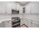 Bright kitchen with quartz counters, stainless appliances, white cabinets, and modern hardware at 555 N Orange Ave # 307, Sarasota, FL 34236
