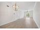 Spacious living room featuring wood-look tile floors and modern globe chandelier at 555 N Orange Ave # 307, Sarasota, FL 34236
