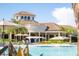 View of the clubhouse and pool area, showcasing umbrella-shaded lounge seating and manicured landscaping at 5685 Palmer Cir # 204, Lakewood Ranch, FL 34211