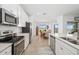 Bright kitchen with stainless steel appliances, white cabinets, and a view of the dining area at 5685 Palmer Cir # 204, Lakewood Ranch, FL 34211