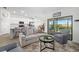 Open-concept living room with a kitchen, tile floors, and sliding glass doors to a screened patio at 5685 Palmer Cir # 204, Lakewood Ranch, FL 34211