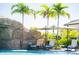 Poolside lounge chairs surrounded by tropical landscaping near a grotto with flowing water at 5685 Palmer Cir # 204, Lakewood Ranch, FL 34211