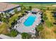 Aerial view of a community pool with lounge seating, palm trees, and a cabana at 5685 Palmer Cir # 204, Lakewood Ranch, FL 34211