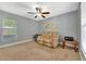 Comfortable bedroom showcasing a ceiling fan, a cozy couch, and a view of the window at 5705 Garden Lakes Majestic, Bradenton, FL 34203