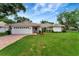 Well-maintained home with tile roof, lush lawn, and brick-paved driveway leading to a two-car garage at 5705 Garden Lakes Majestic, Bradenton, FL 34203