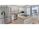 Modern kitchen features stainless steel appliances, white cabinetry, granite countertops, and an island cooktop at 5705 Garden Lakes Majestic, Bradenton, FL 34203