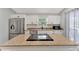 Modern kitchen features stainless steel appliances, white cabinetry, granite countertops, and an island cooktop at 5705 Garden Lakes Majestic, Bradenton, FL 34203
