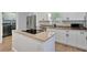 Modern kitchen features stainless steel appliances, white cabinetry, granite countertops, and an island cooktop at 5705 Garden Lakes Majestic, Bradenton, FL 34203