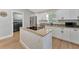 Modern kitchen features stainless steel appliances, white cabinetry, granite countertops, and an island cooktop at 5705 Garden Lakes Majestic, Bradenton, FL 34203