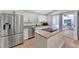 Modern kitchen features stainless steel appliances, white cabinetry, granite countertops, and an island cooktop at 5705 Garden Lakes Majestic, Bradenton, FL 34203