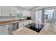 Modern kitchen features stainless steel appliances, white cabinetry, granite countertops, and an island cooktop at 5705 Garden Lakes Majestic, Bradenton, FL 34203