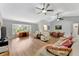 Spacious living room with fan, wood flooring, study nook, dining room, and modern furnishings at 5705 Garden Lakes Majestic, Bradenton, FL 34203