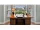 Bright home office featuring a large wooden desk and natural light from a beautiful bay window at 5705 Garden Lakes Majestic, Bradenton, FL 34203
