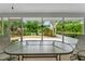 The screened patio with a table overlooks the beautifully landscaped backyard at 5705 Garden Lakes Majestic, Bradenton, FL 34203