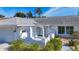 Home exterior featuring an arched entry, attached garage, and mature landscaping at 6012 11Th W Ave, Bradenton, FL 34209