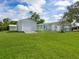 Large backyard with a shed, sunroom, and lush green grass at 6116 Rodgers Ave, Sarasota, FL 34231