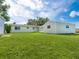 Backyard featuring well-maintained lawn and includes shed and a main house with a sunroom at 6116 Rodgers Ave, Sarasota, FL 34231