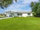 Well-maintained single-story home boasts a lush green lawn and a cozy carport in a peaceful setting at 6116 Rodgers Ave, Sarasota, FL 34231