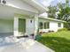 Close-up of the home's entrance featuring a lush lawn and well-maintained landscaping at 6116 Rodgers Ave, Sarasota, FL 34231