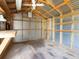 Inside shed with a work bench, ceiling fan, wood framing and metal siding and exposed rafters at 6116 Rodgers Ave, Sarasota, FL 34231