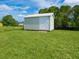 This shed has a white door and is surrounded by a lush green lawn, providing ample storage space at 6116 Rodgers Ave, Sarasota, FL 34231