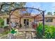 Comfortable covered patio with outdoor furniture, ideal for enjoying the surrounding garden and backyard views at 620 Burke Rd, Venice, FL 34293