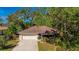 Charming single-story home with a well-maintained lawn, mature trees, and a two-car garage at 620 Burke Rd, Venice, FL 34293