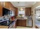 Kitchen with stainless steel appliances, dark wood cabinetry, and granite countertops at 620 Burke Rd, Venice, FL 34293
