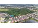 Aerial view of a residential area featuring a lake and community tennis courts, surrounded by lush greenery at 6240 Falcon Lair Dr, North Port, FL 34287