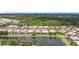 Scenic aerial view of residences backing onto a serene lake, surrounded by mature trees and landscaping at 6240 Falcon Lair Dr, North Port, FL 34287