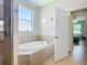 Relaxing bathroom showcases a soaking tub, ceramic tile and a large window at 6240 Falcon Lair Dr, North Port, FL 34287