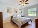 Cozy bedroom with light blue walls, wood flooring, beach-themed decor and a bright window at 6240 Falcon Lair Dr, North Port, FL 34287