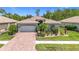Charming single-story home featuring a beautiful terracotta tile roof, two-car garage, and lush landscaping at 6240 Falcon Lair Dr, North Port, FL 34287