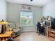 Bright home office with a computer setup, comfortable chair, and large window offering natural light at 6240 Falcon Lair Dr, North Port, FL 34287