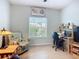 Bright home office with large window, modern desk setup, and a comfortable reading chair at 6240 Falcon Lair Dr, North Port, FL 34287