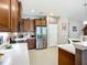 Modern kitchen with stainless steel fridge, marble countertops, and wooden cabinets at 6240 Falcon Lair Dr, North Port, FL 34287