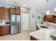 Modern kitchen with stainless steel fridge, marble countertops, and wooden cabinets at 6240 Falcon Lair Dr, North Port, FL 34287