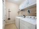 Bright laundry room featuring white cabinets and washer and dryer at 6240 Falcon Lair Dr, North Port, FL 34287