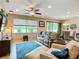 Comfortable living room featuring a plush sofa, ceiling fan, and a large window with a peaceful view at 6240 Falcon Lair Dr, North Port, FL 34287
