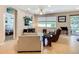 Inviting living room with neutral tones, comfortable seating, and a view into the adjacent bedroom at 6240 Falcon Lair Dr, North Port, FL 34287