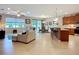 Open-concept living space with kitchen island, dining area, and comfortable lounge furniture at 6240 Falcon Lair Dr, North Port, FL 34287