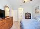 The main bedroom is spacious and features a dresser, a bed with blue linens, and wood-look floors at 6240 Falcon Lair Dr, North Port, FL 34287