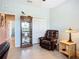 Cozy office space with a leather recliner, display cabinet, and natural light from the window at 6240 Falcon Lair Dr, North Port, FL 34287
