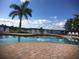 Community pool featuring a large sun deck, clear blue water, and several chairs for residents at 6240 Falcon Lair Dr, North Port, FL 34287