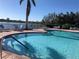 Inviting community pool with lake view, lounge seating, and beautiful clear water, perfect for relaxation at 6240 Falcon Lair Dr, North Port, FL 34287
