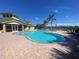 Beautiful pool area with clear blue water and lounge chairs under palm trees on a sunny day at 6240 Falcon Lair Dr, North Port, FL 34287